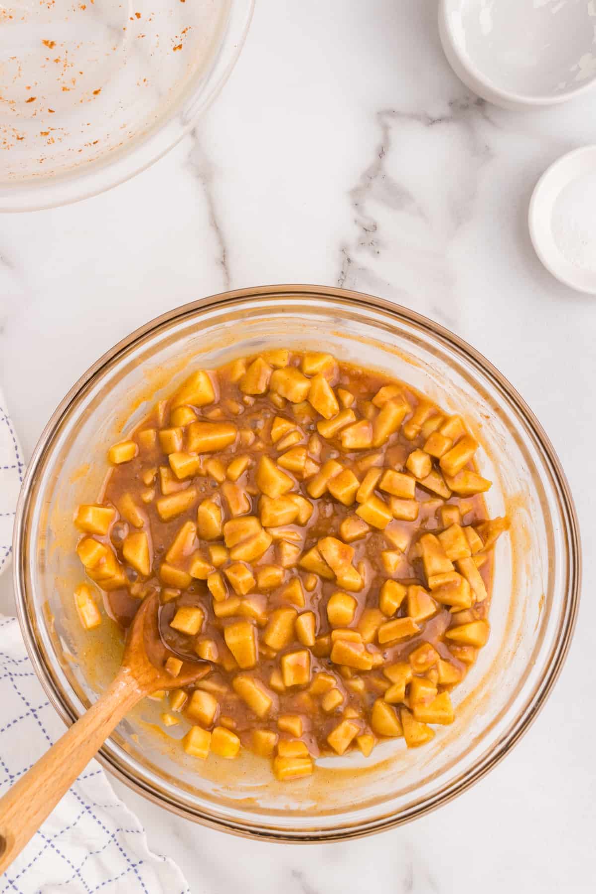 Using wooden spoon to combine caramel mixture for Salted Caramel Apple Bars