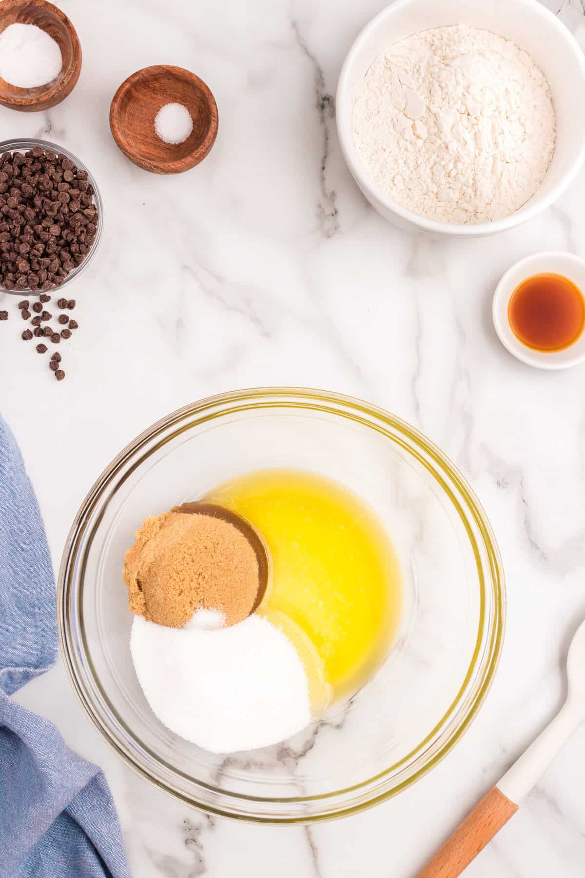 Creaming together sugars and melted butter for cookie base of Slutty Cheesecake Bars