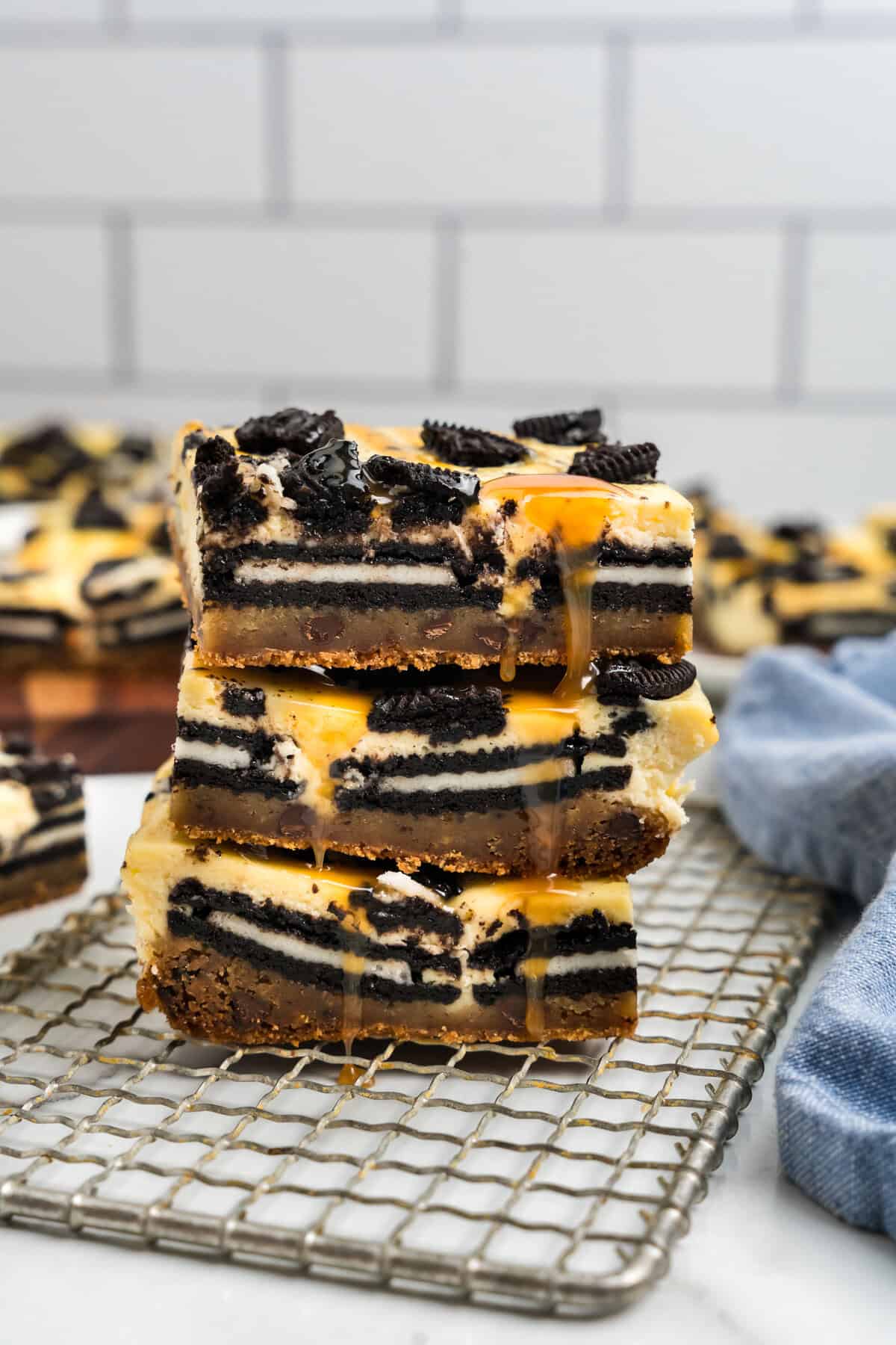 Slutty Cheesecake Bars stacked on wire cooling rack