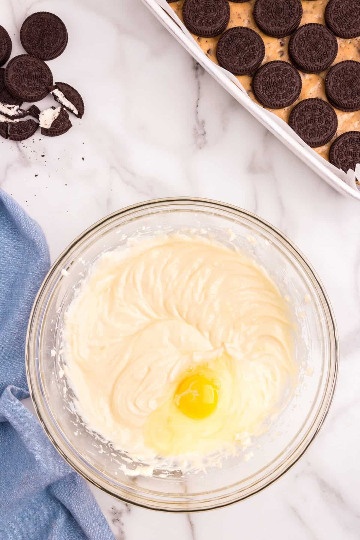 Creaming together cheesecake batter in mixing bowl for Slutty Cheesecake Bars recipe