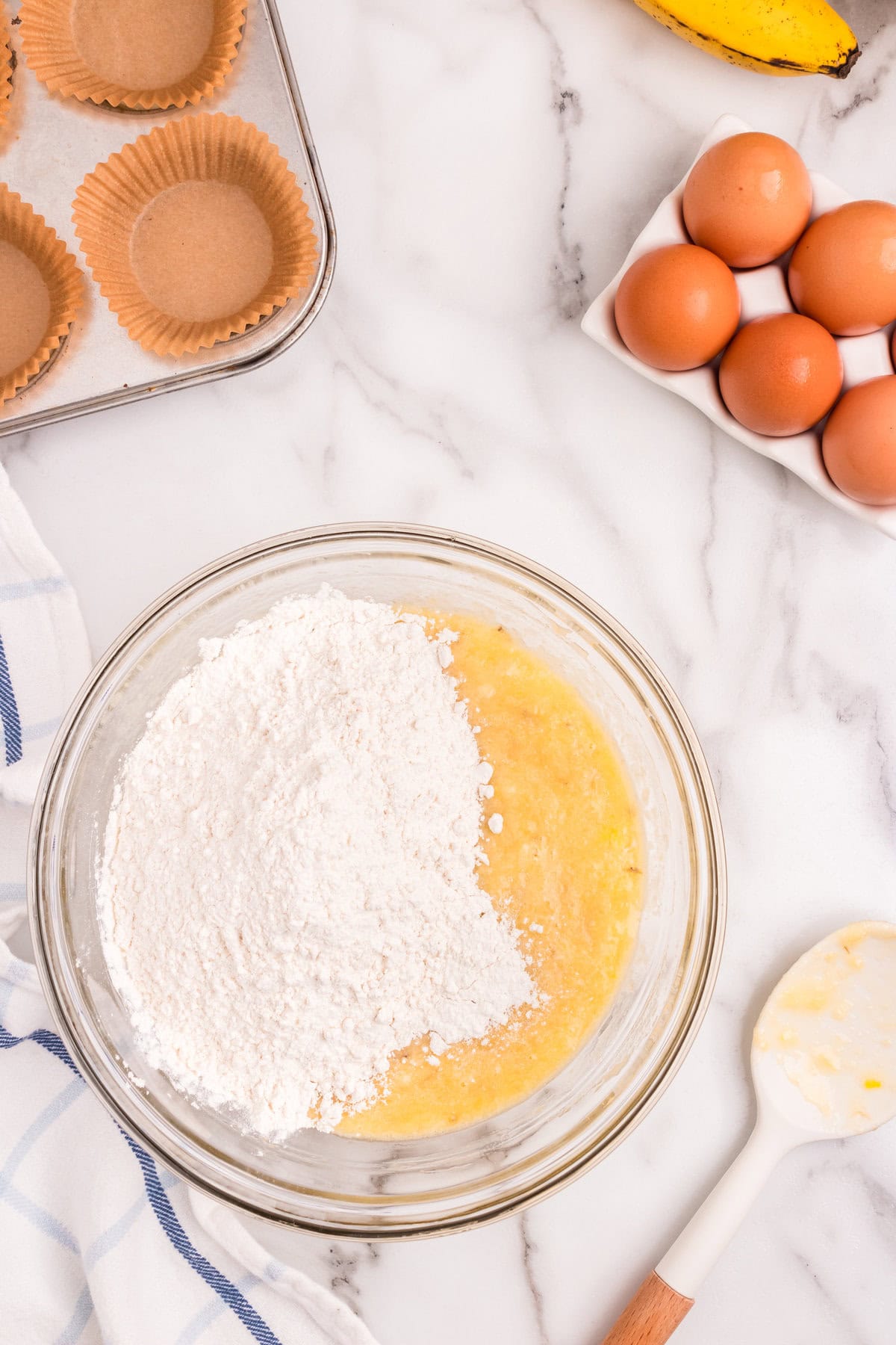 Combining wet and dry ingredients for Banana Crumb Muffins in mixing bowl