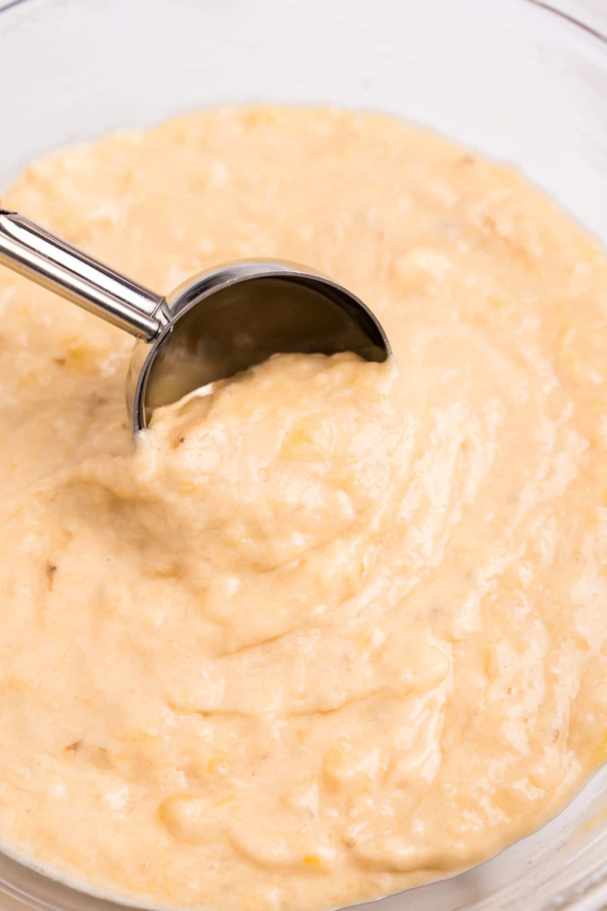 Scooping Banana Crumb Muffins batter from bowl