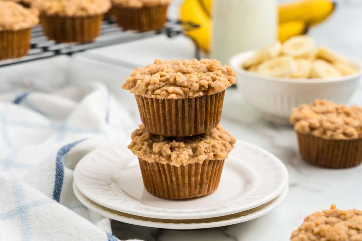 Two Banana Crumb Muffins stacked on white plate