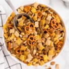 Square overhead image of Chex Mix in serving bowl with scooper