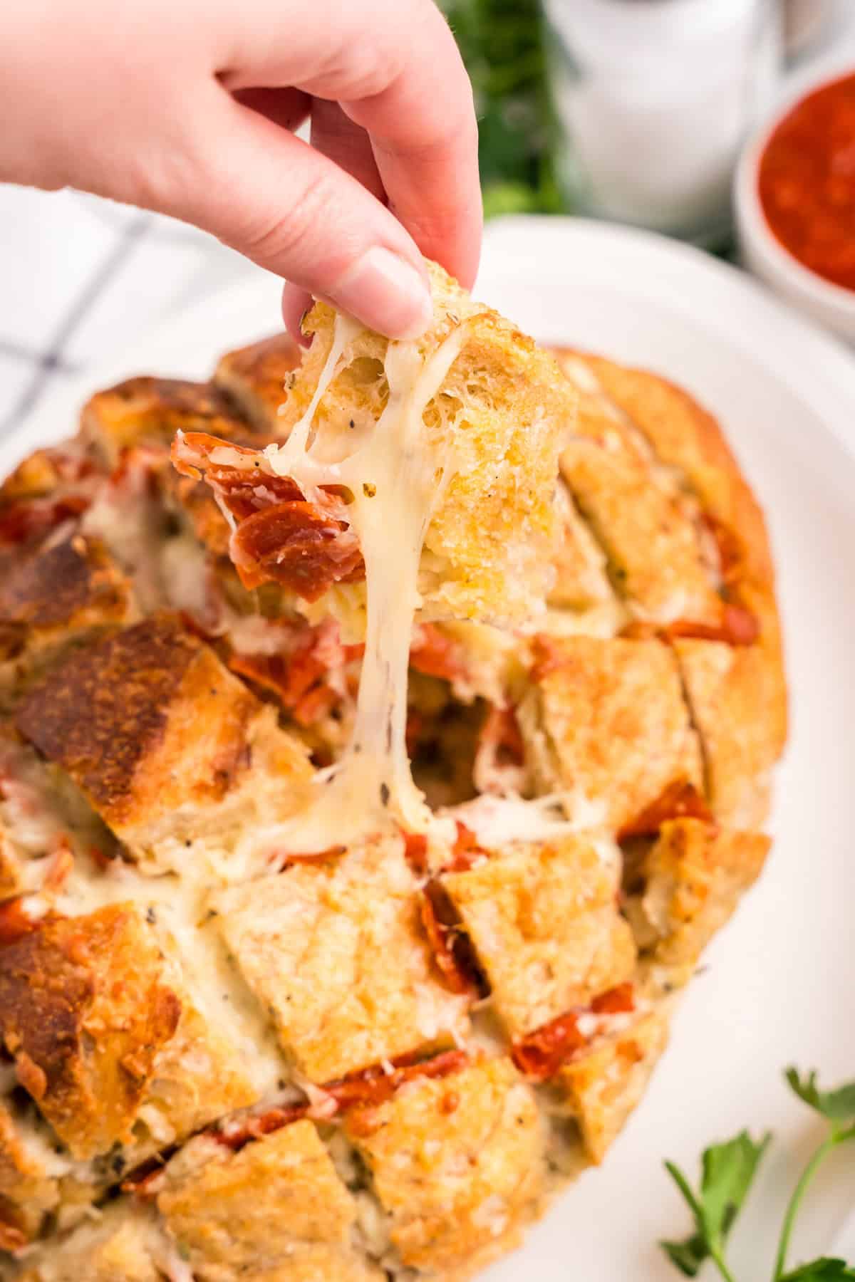 Lifing Pizza Pull Apart Bread piece on serving plate