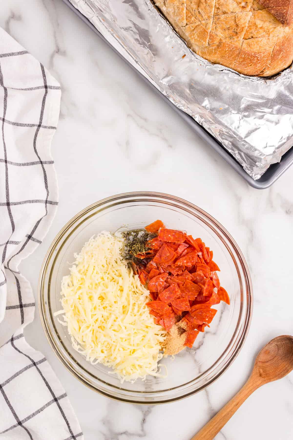 Pull Apart Pizza Bread filling ingredients in glass mixing bowl