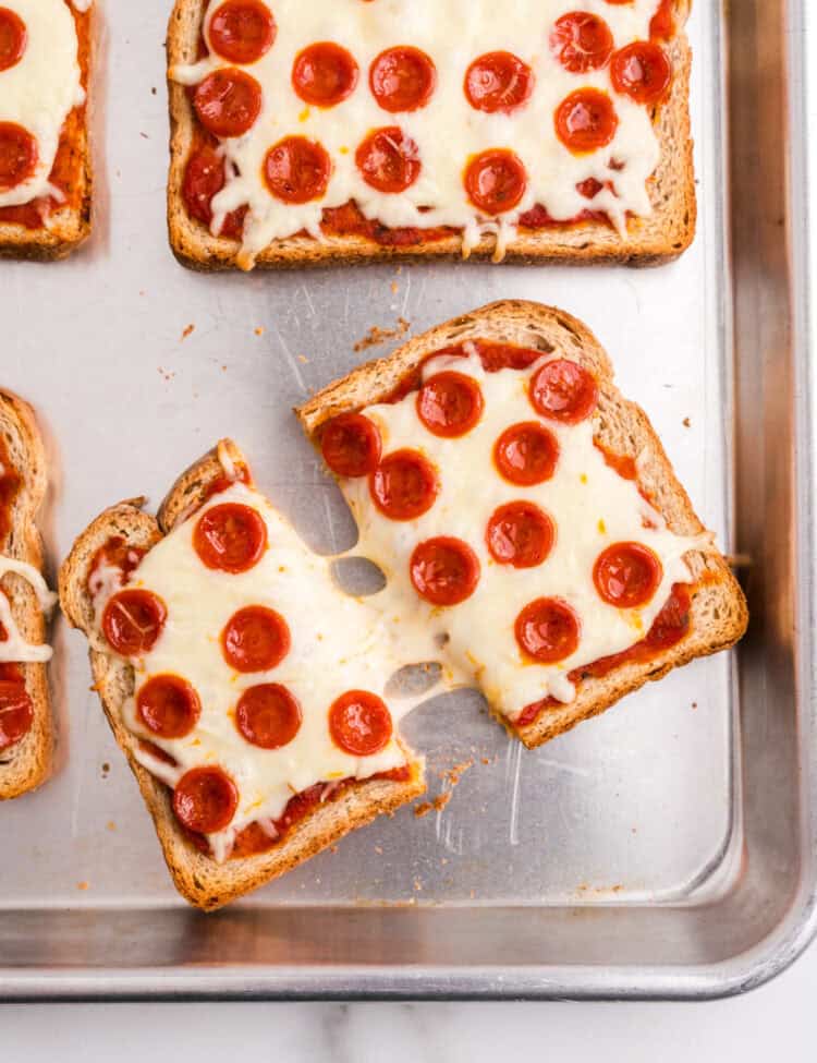 Pizza toast cut in half showing the gooey cheese