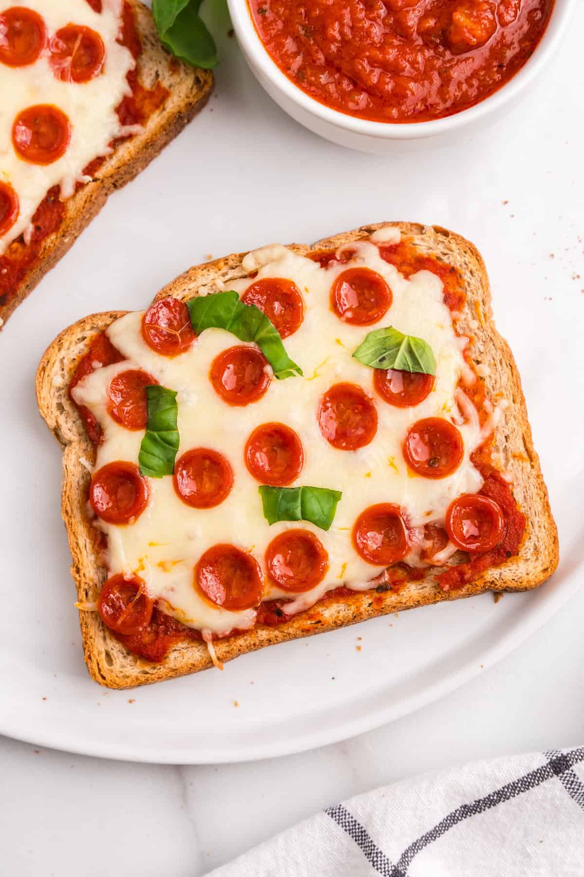 Pizza Slice displayed on a white plate with dipping sauce
