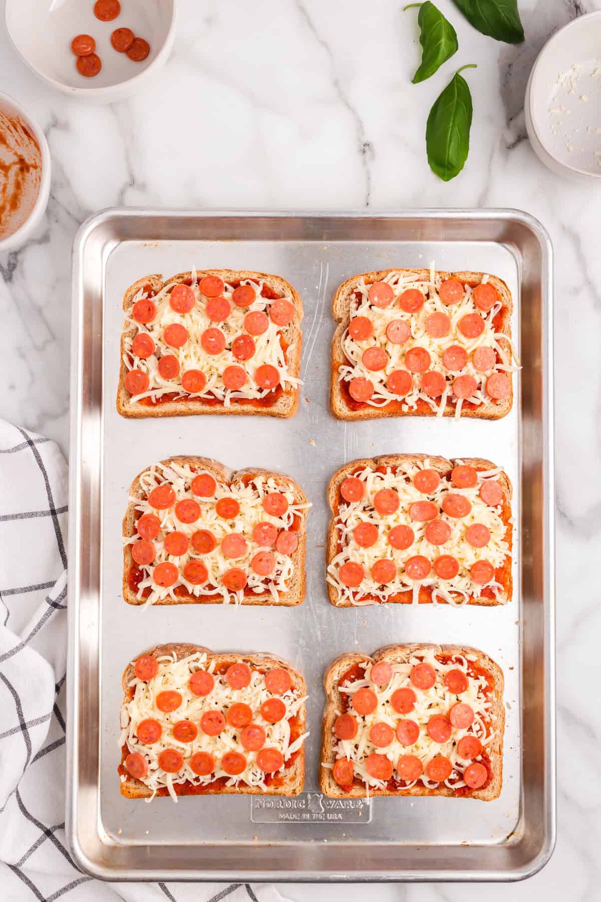 Add the mini pepperonis on top of the cheese.