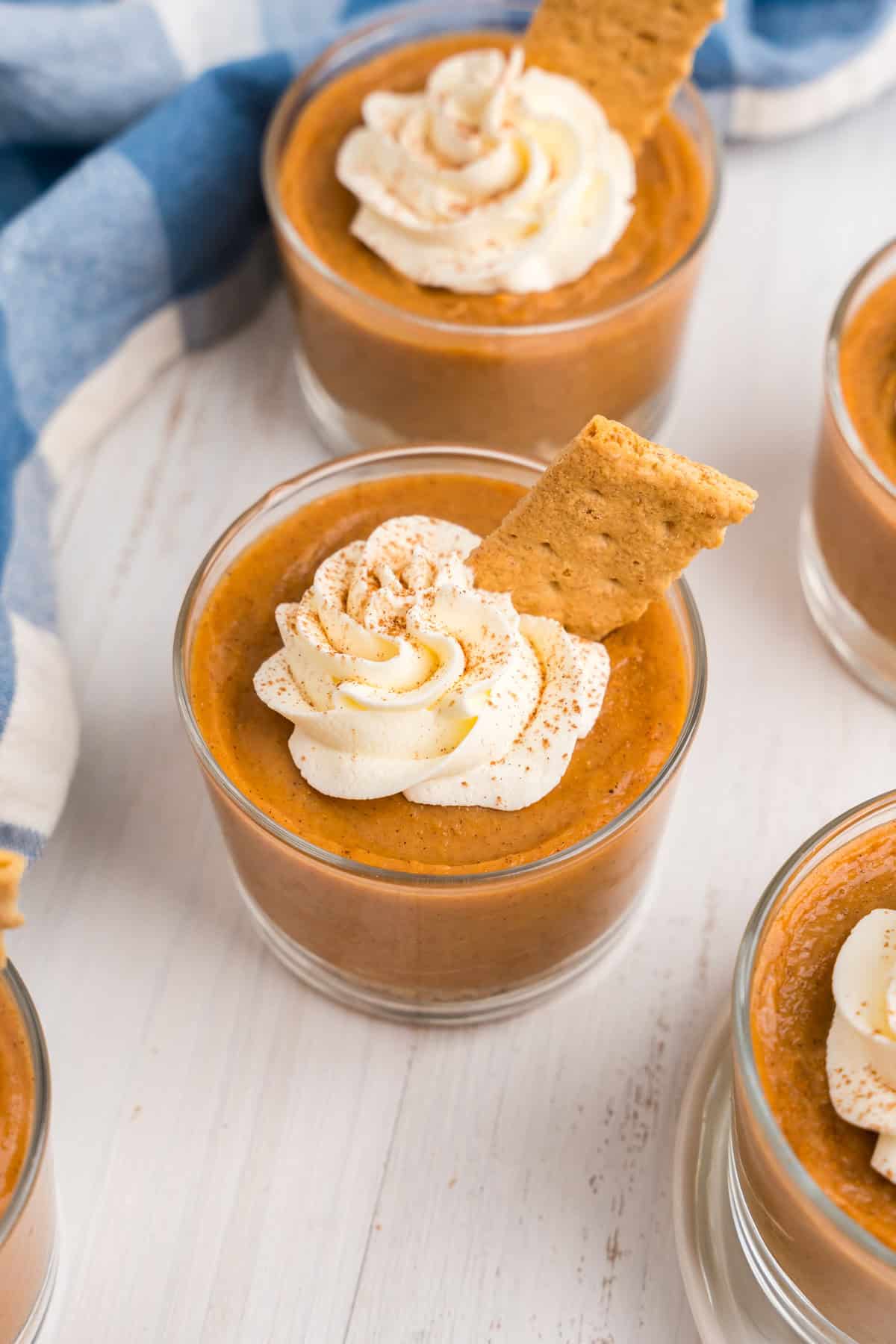 Pumpkin Pie in a Bag layered in small glass cup topped with whipped topping and graham cracker