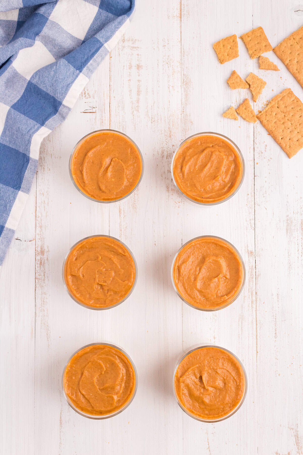 Pumpkin mixture in small cups piped in over graham cracker crust for Pumpkin Pie in a Bag recipe