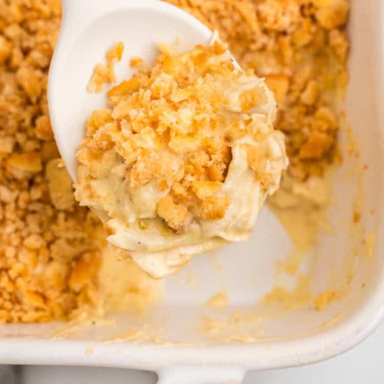 Using large spoon to sccop Ritz Cracker Chicken Casserole from baking dish