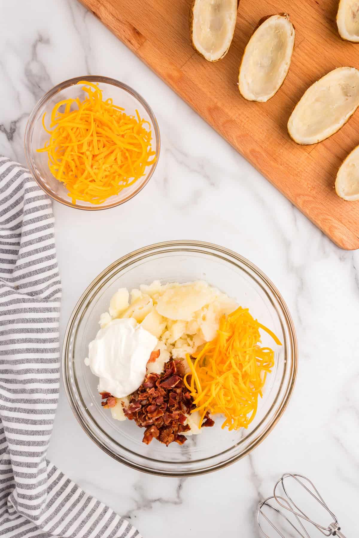 Ingredients for Twice Baked Potatoes in glass mixing bowl prior to combining