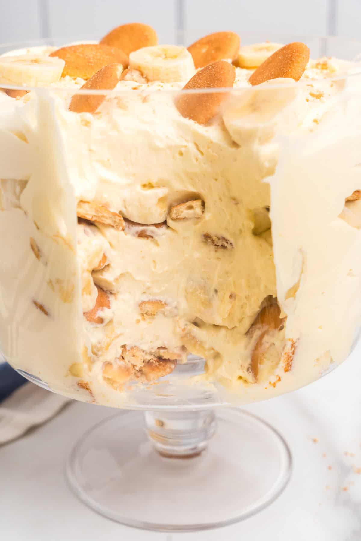Layered Banana Pudding in pedestal bowl with one scoop taken