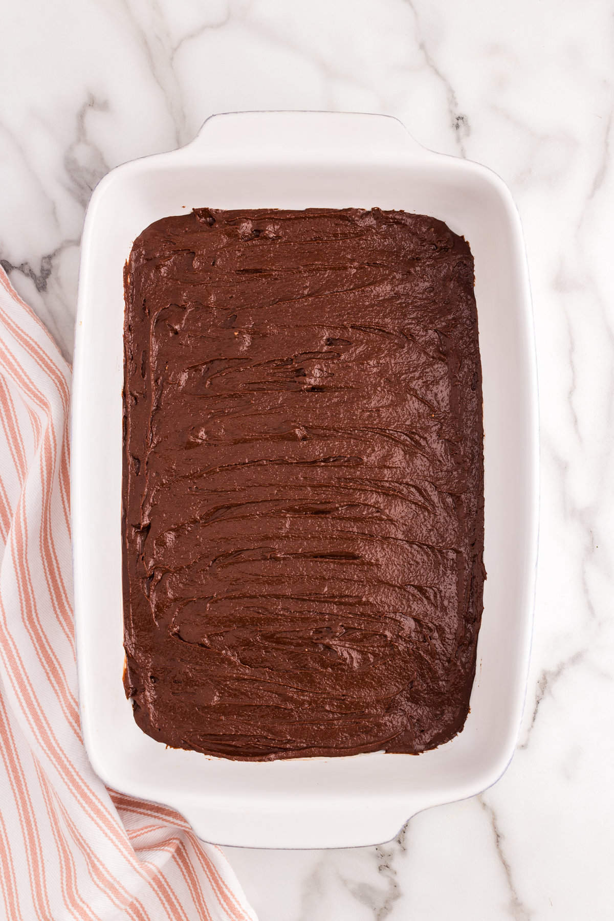Evening spreading Homemade Brownies batter in 9x13 baking pan