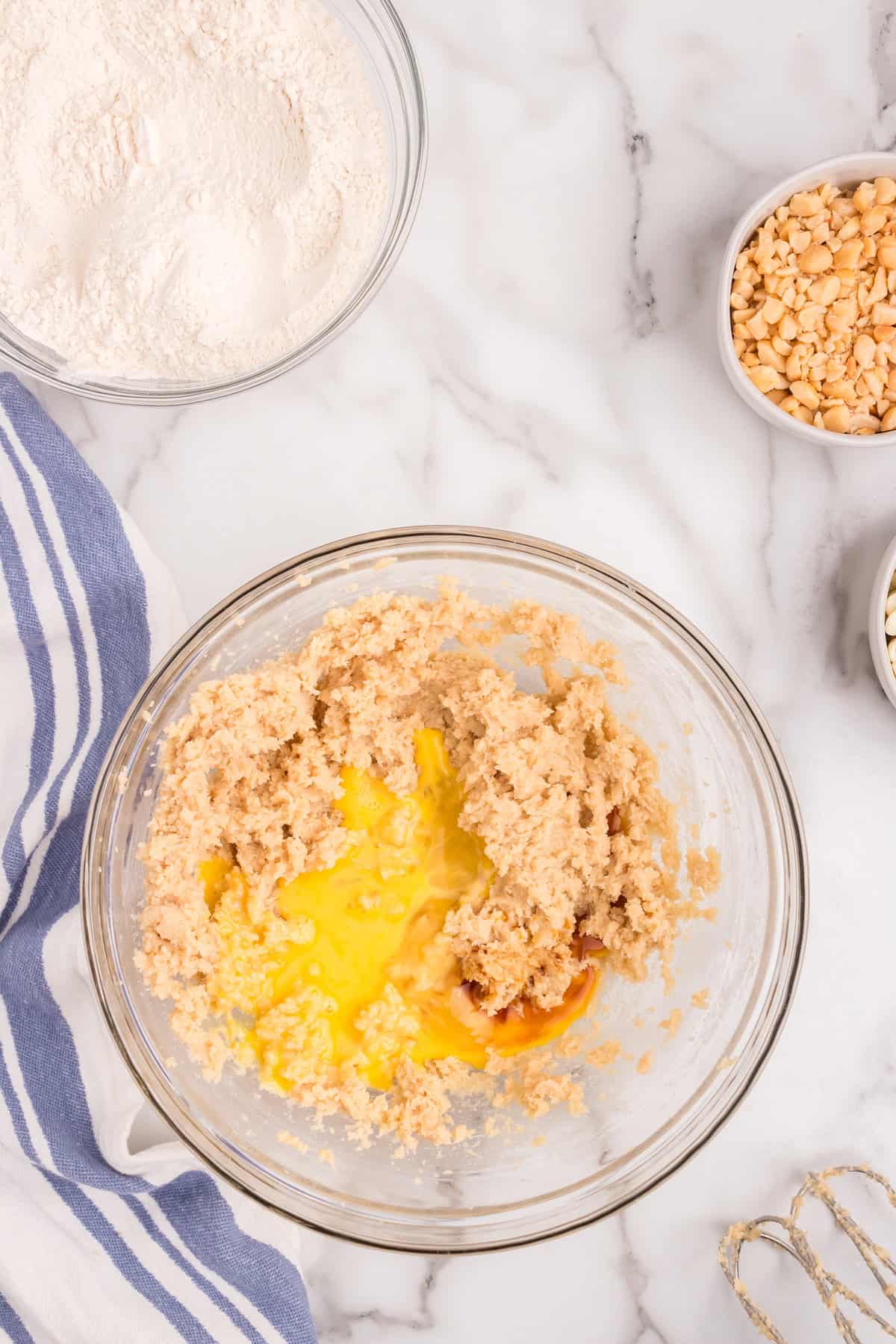 Mixing wet ingredients into White Chocolate Macadamia Nut Cookies mixture