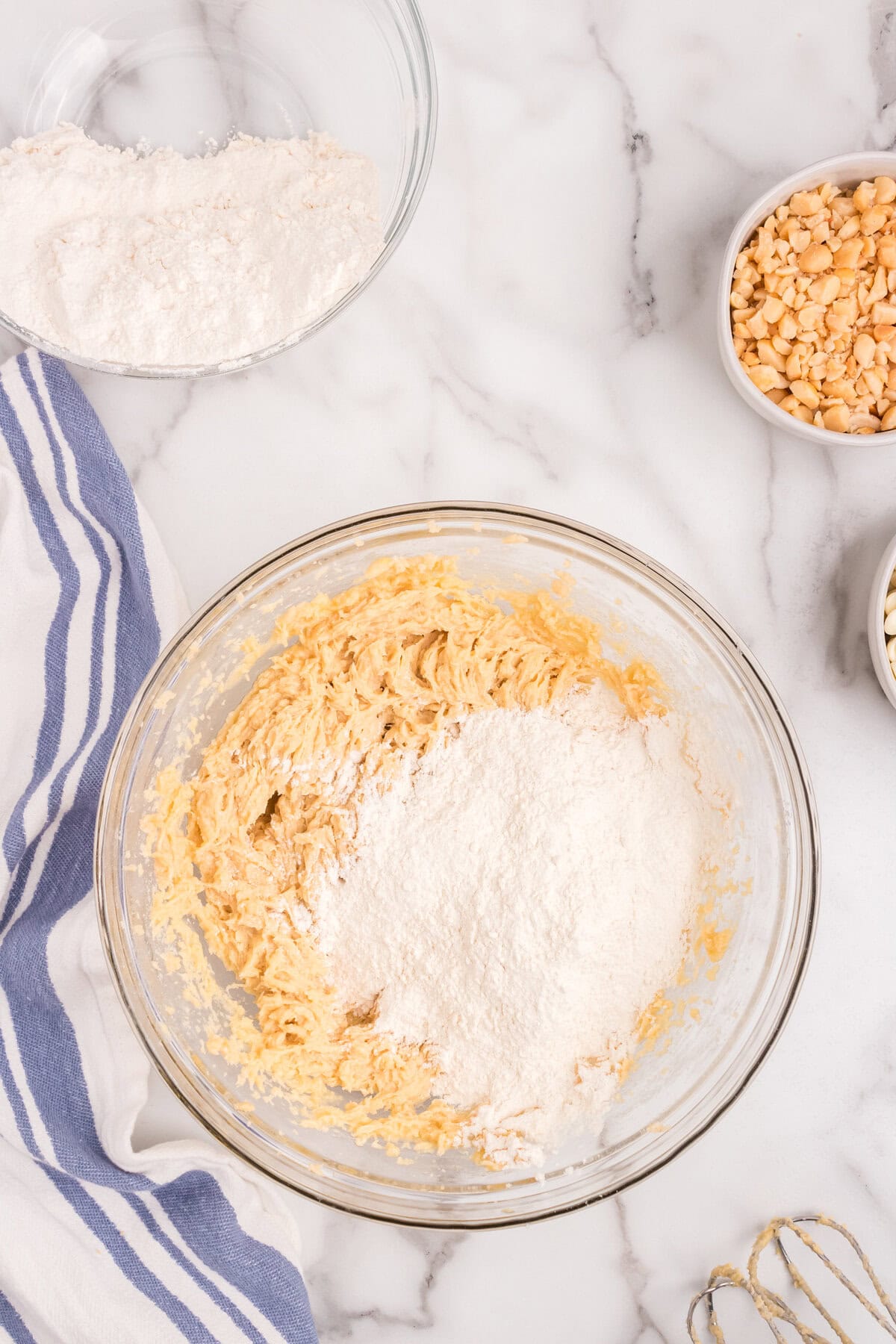 Mixing together ingredients for Macadamia Nut and White Chocolate Cookies in glass bowl