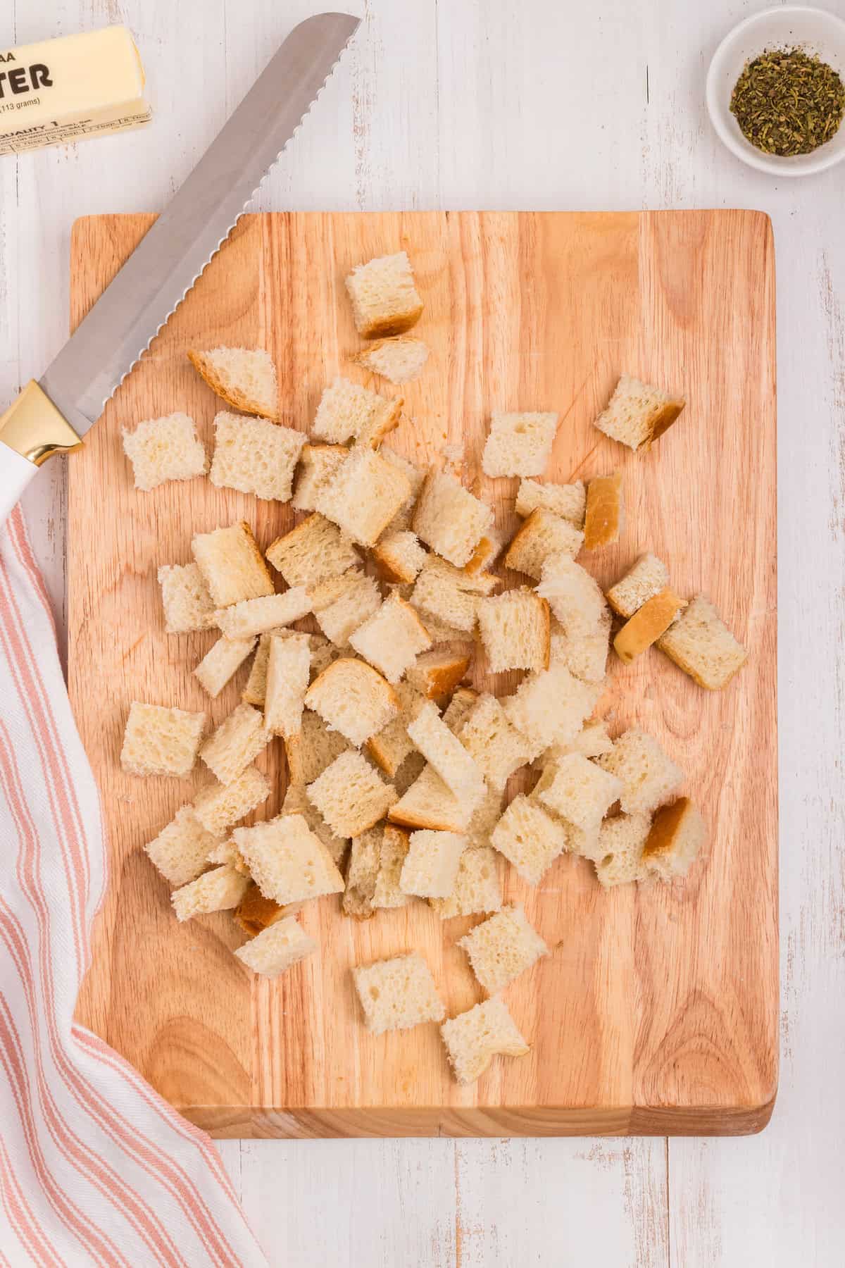 Cubed bread on wooden cutting board for Air Fryer Croutons recipe