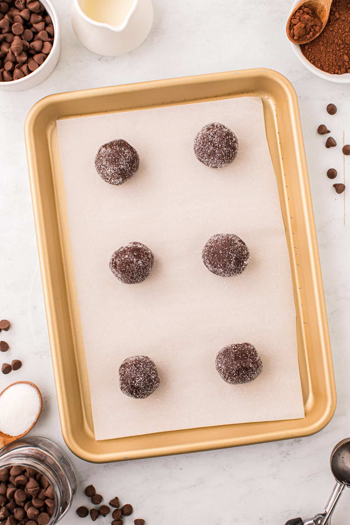 Chocolate Thumbprint Cookies sugared dough balls on parchment-lined cookie sheet