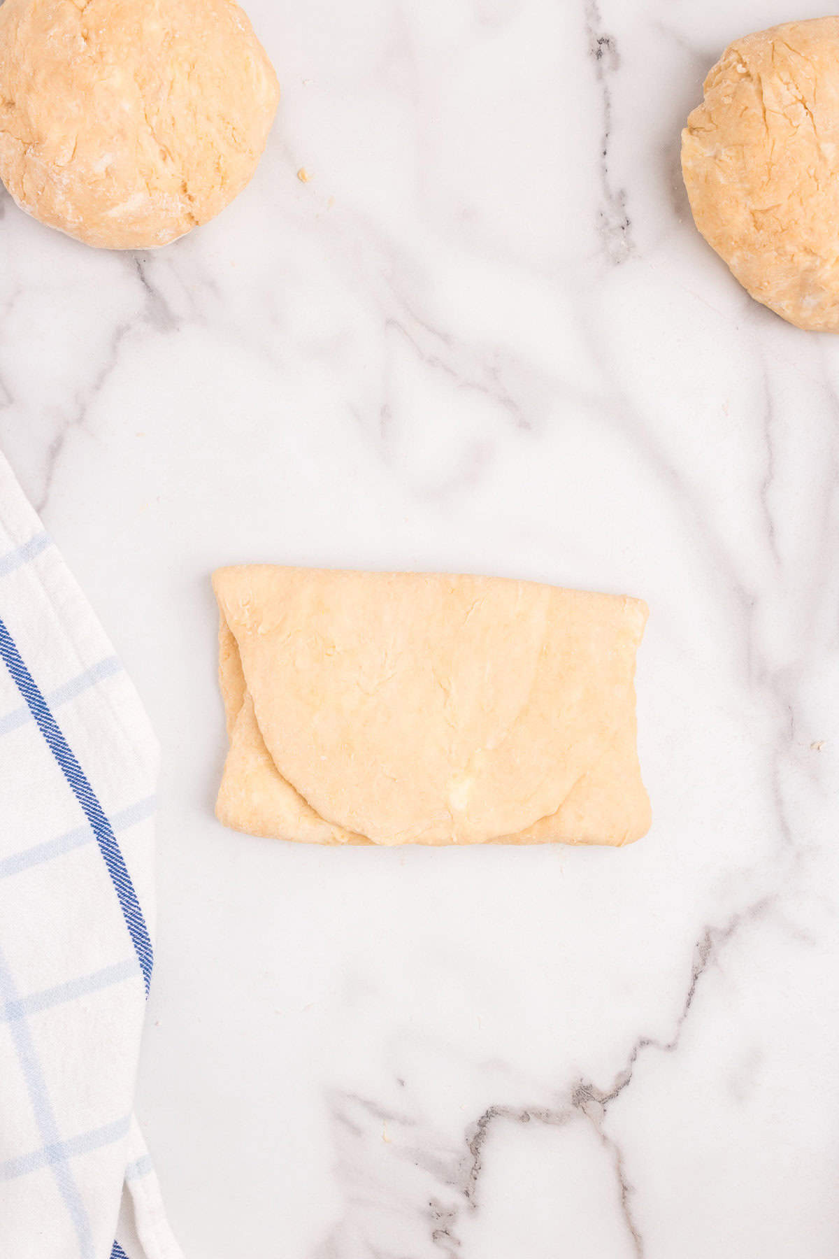 Rolled out Homemade Crescent Rolls dough folded into thirds