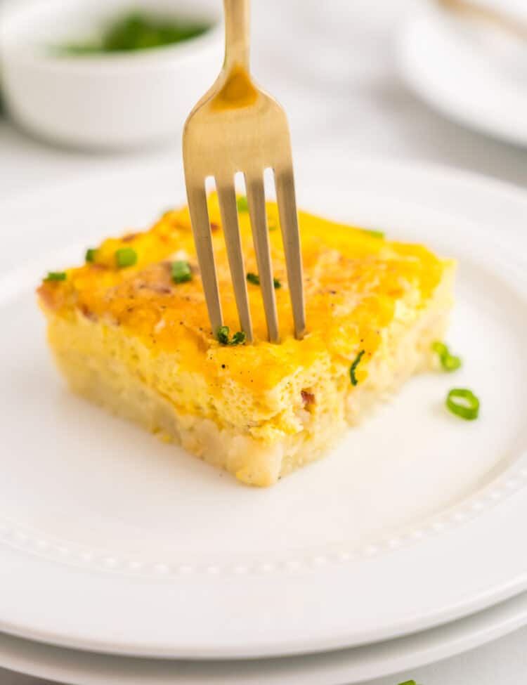 Fork taking bite out of egg bake on plate