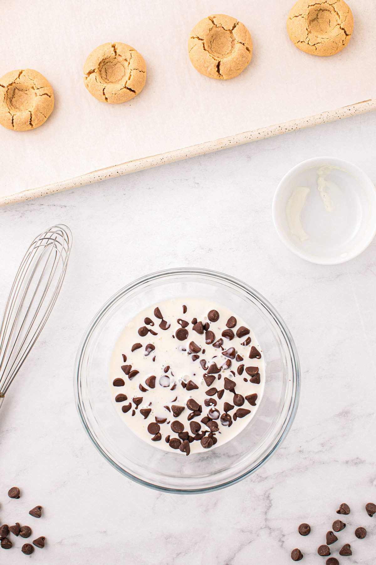 Adding heavy cream to the chocolate chips in small bowl for ganache for the  Peanut Butter Thumbprint Cookies recipe