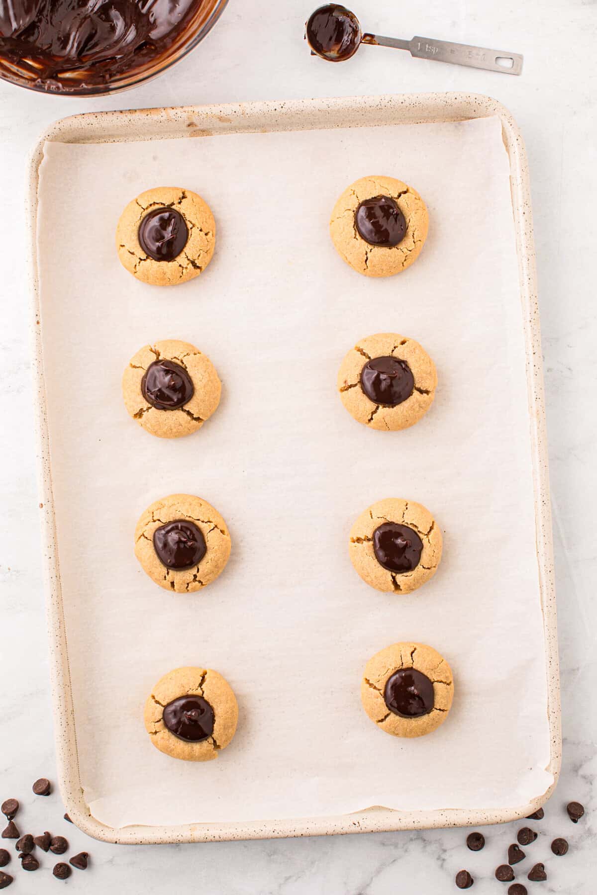 Filling the indents in the cookies with ganache for the Peanut Butter Thumbprint Cookies