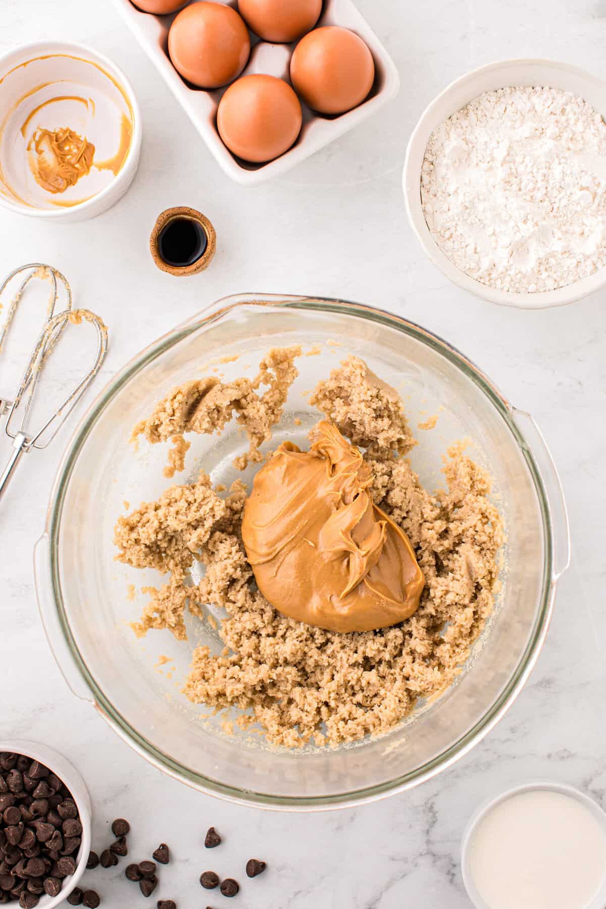 Creamed together butter and sugars with peanut butter added to mixing bowl for Peanut Butter Thumbprint Cookies recipe