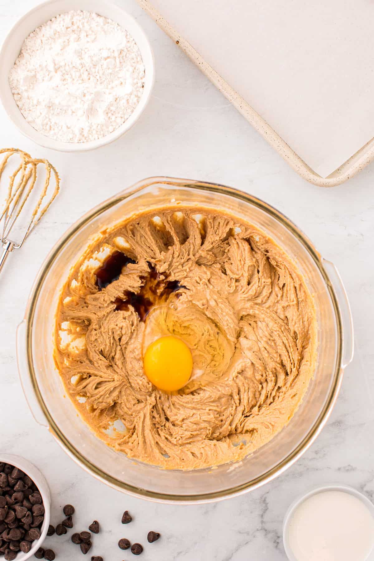 Adding egg and vanilla to Peanut Butter Thumbprint Cookies dough mixture 