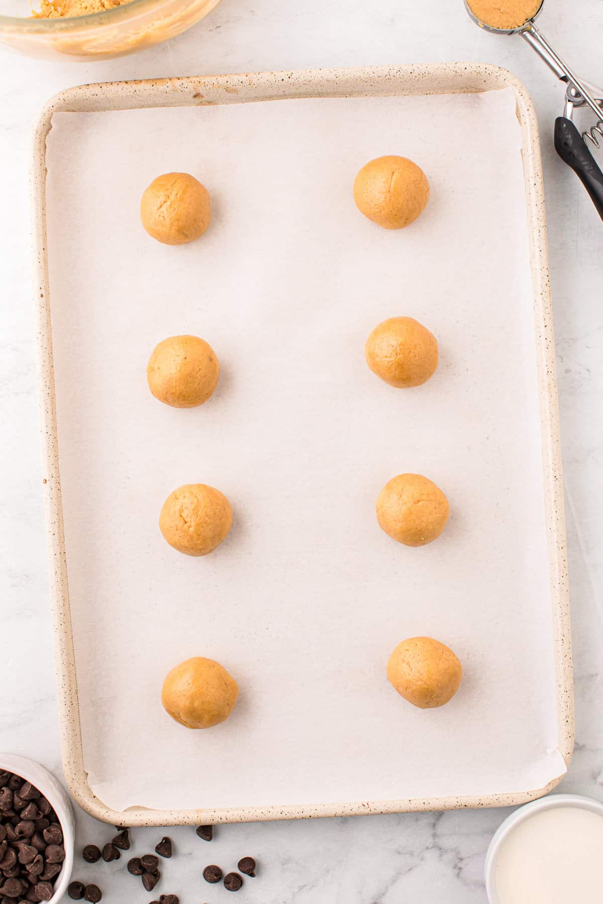 Peanut Butter Thumbprint Cookies rolled into placed and evenly placed on parchment lined cookie sheet