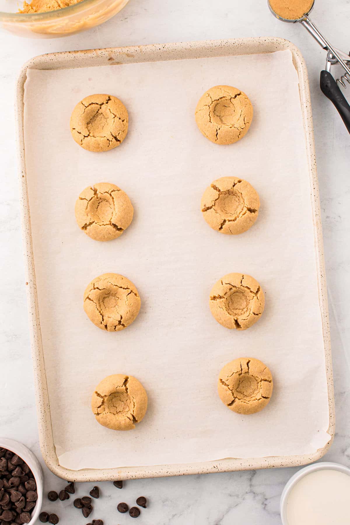 Slightly indenting the cookies after baking on cookie sheet for Peanut Butter Thumbprint Cookies