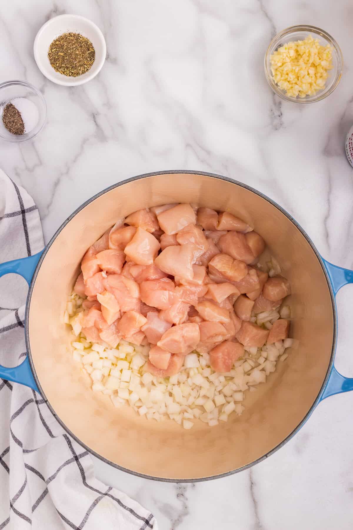 Overhead picture of chicken and onions in a dutch oven.