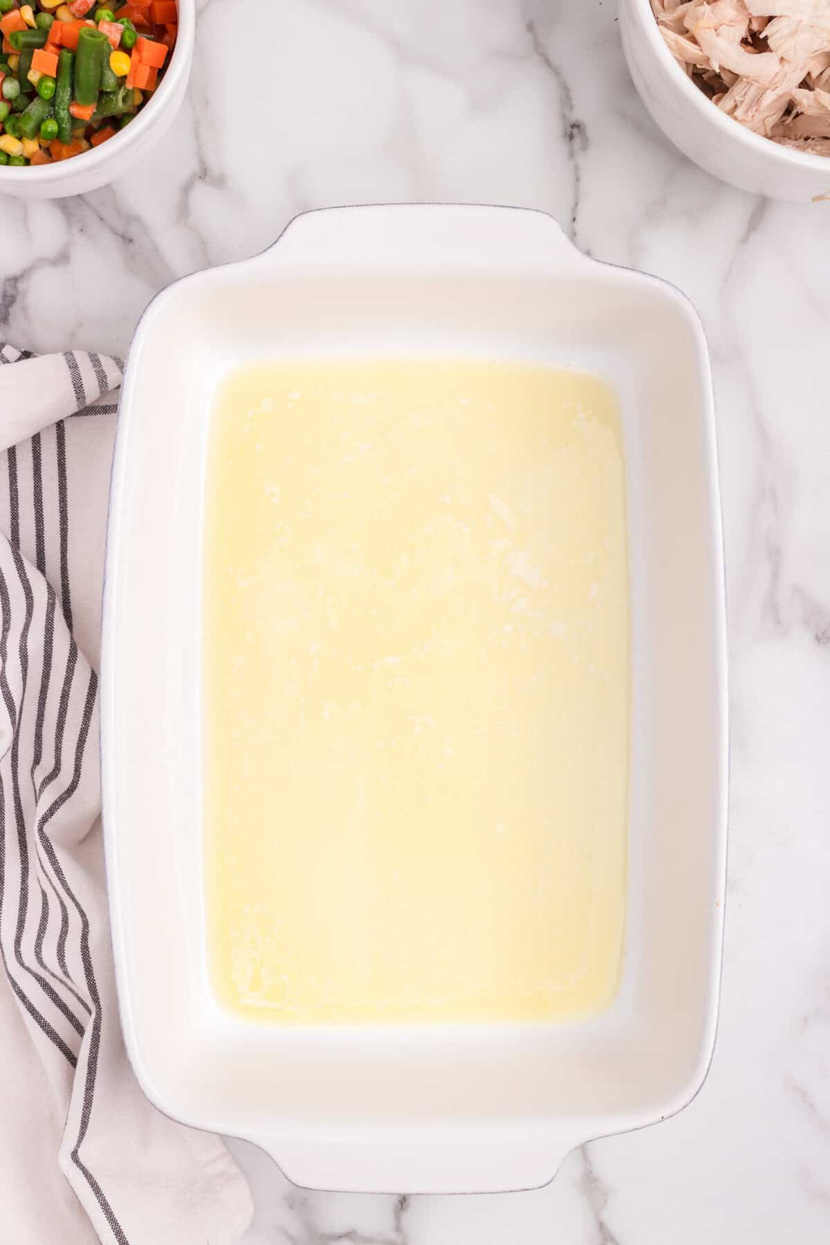 Overhead picture of white pan with melted butter in it.