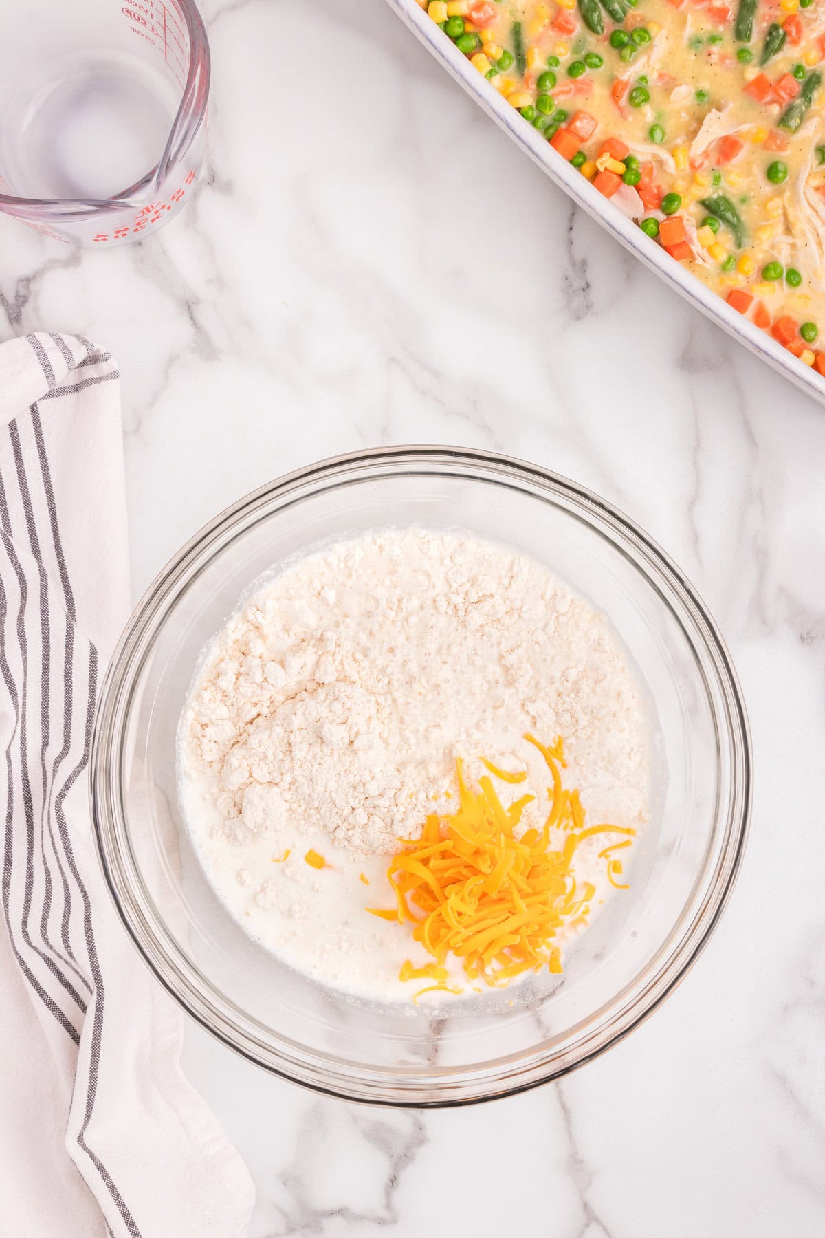 Overhead picture of clear bowl with biscut mix ingredients in it.