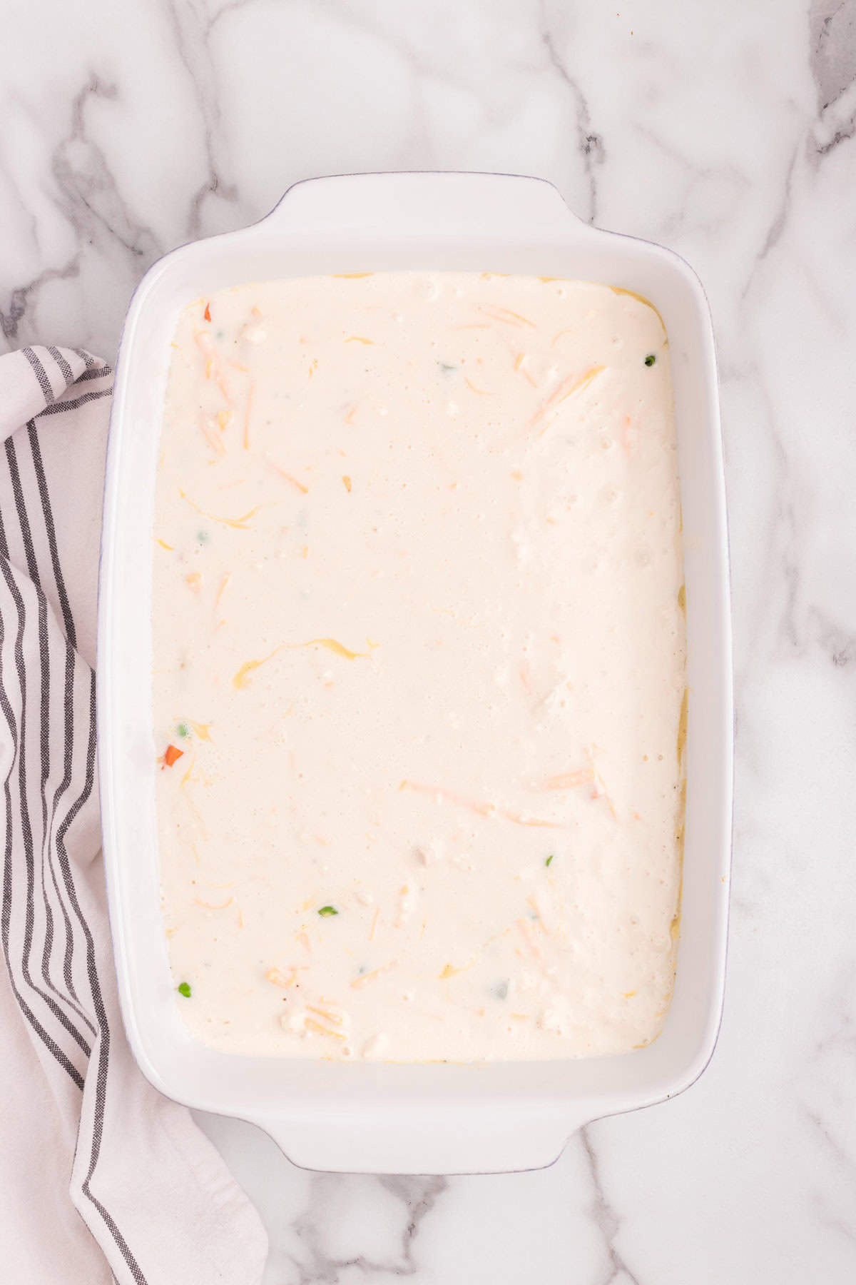 Overhead picture of white baking dish with biscuit mix poured in it.