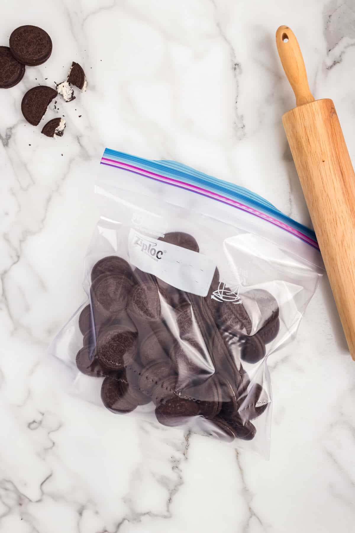 Oreo cookies in ziplock with rolling pin next to bag