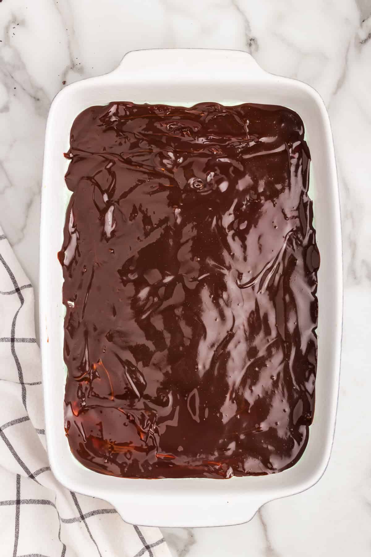 White pan with hot fudge sauce spread out in it