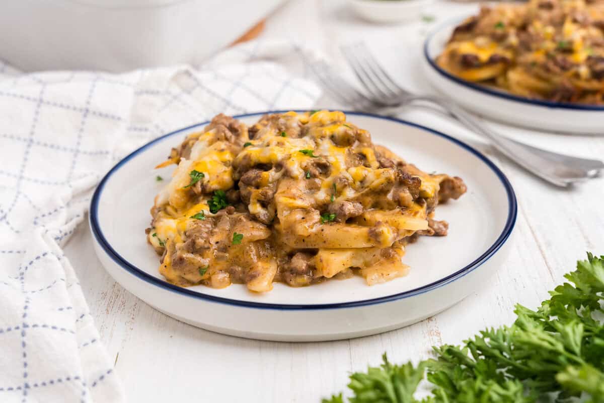 White plate with a serving of completed ground beef and potato casserole on it.