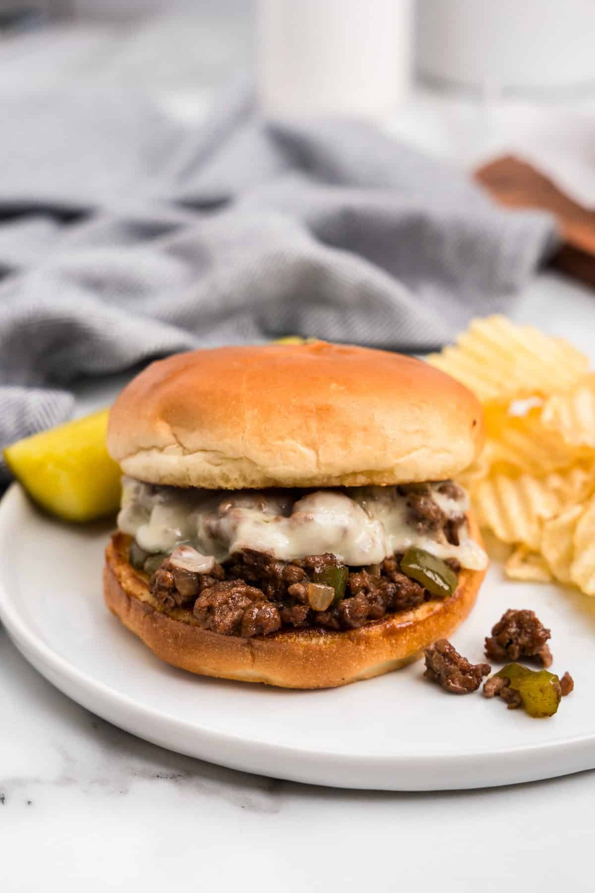 Cheesesteak Sloppy Joe on white plate with chips