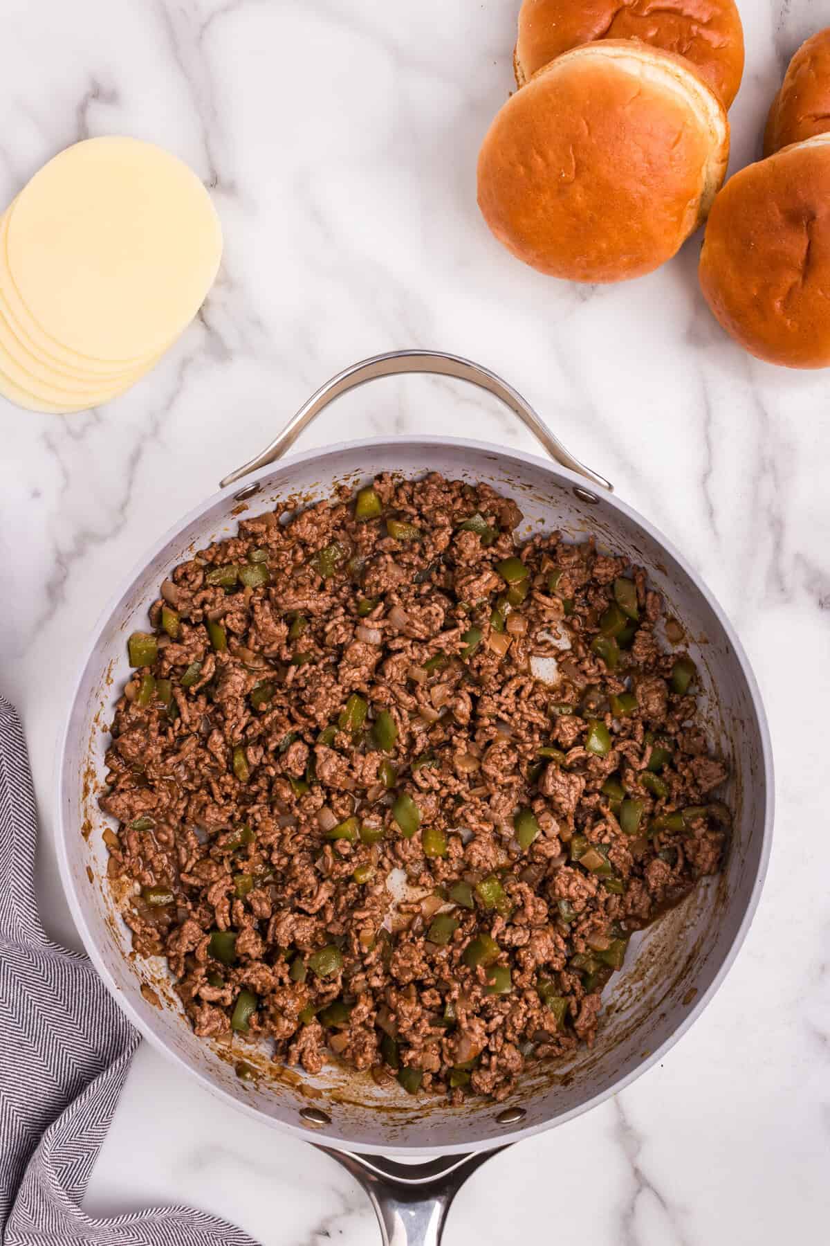 Overhead picture of cooked Cheesesteak Sloppy Joe ingredients combined in a pan.
