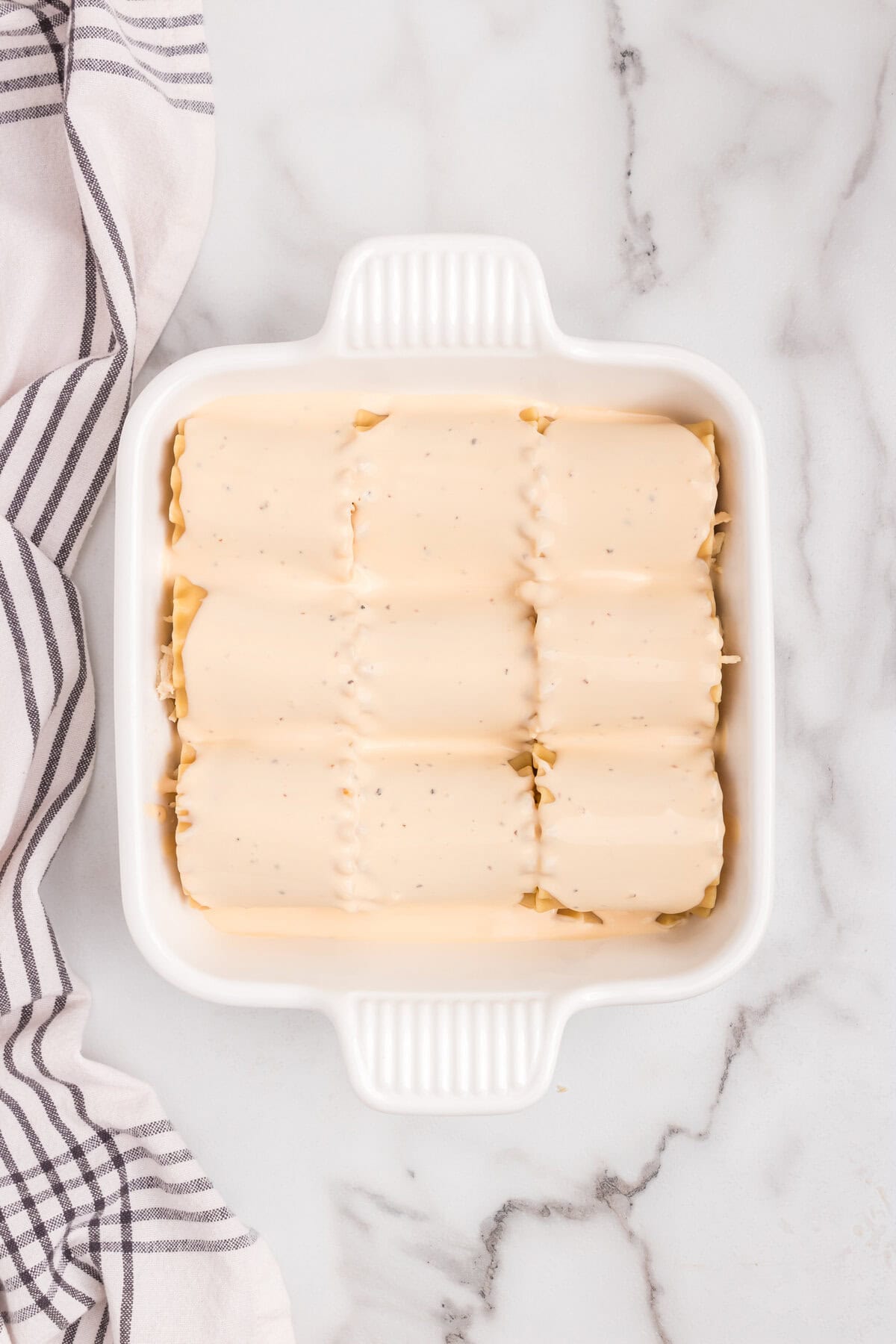 Overhead picture of roll ups in pan with sauce on it
