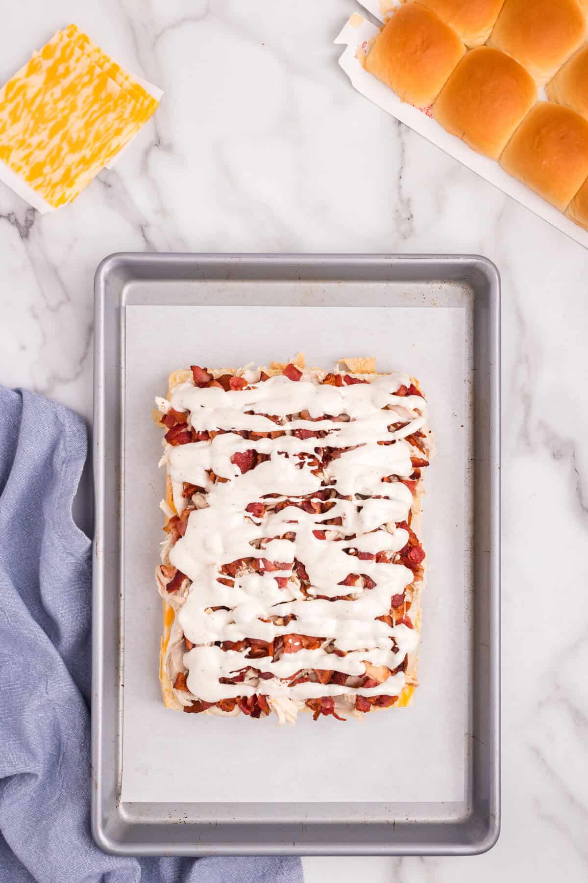 Overhead picture of ranch spread across bacon layer.