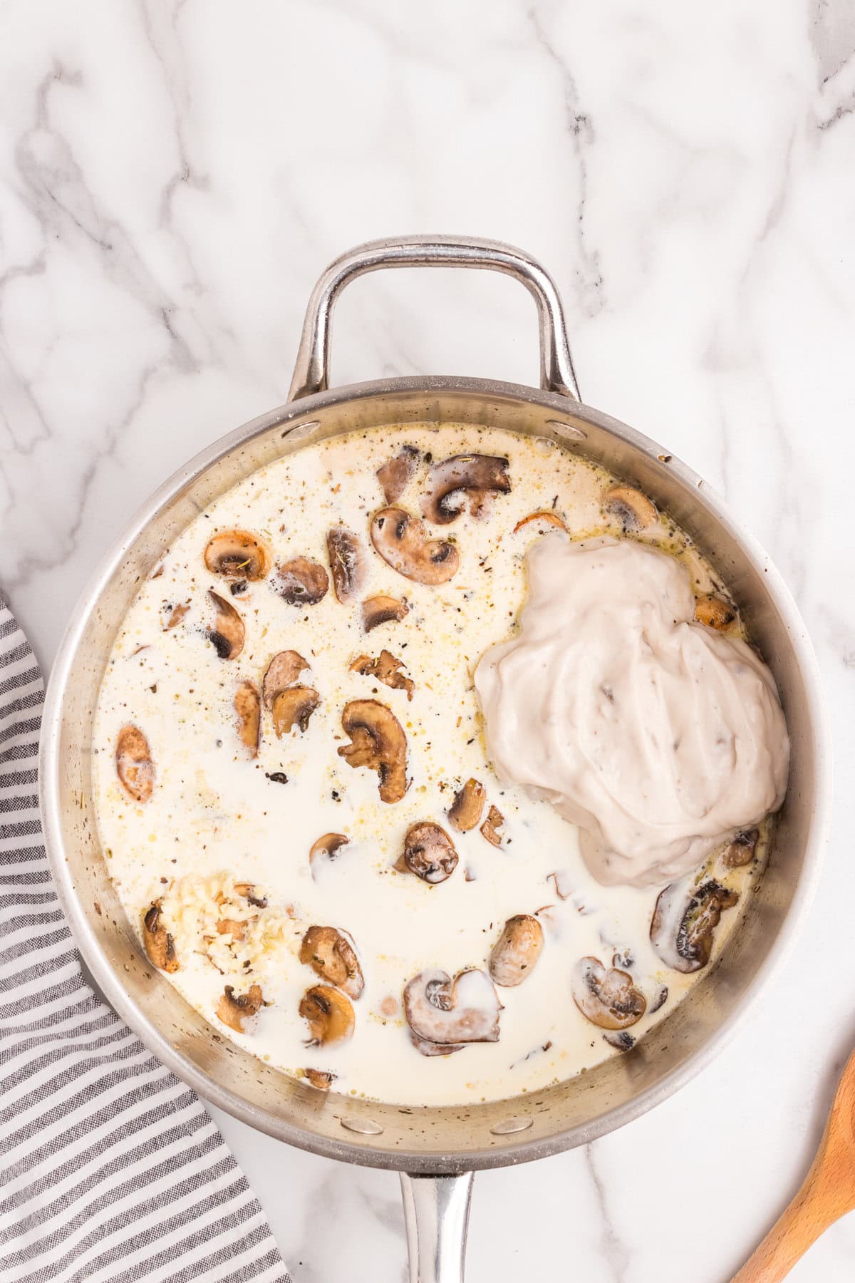 Stirring in Skillet Cream of Mushroom Chicken sauce ingredients in the skillet