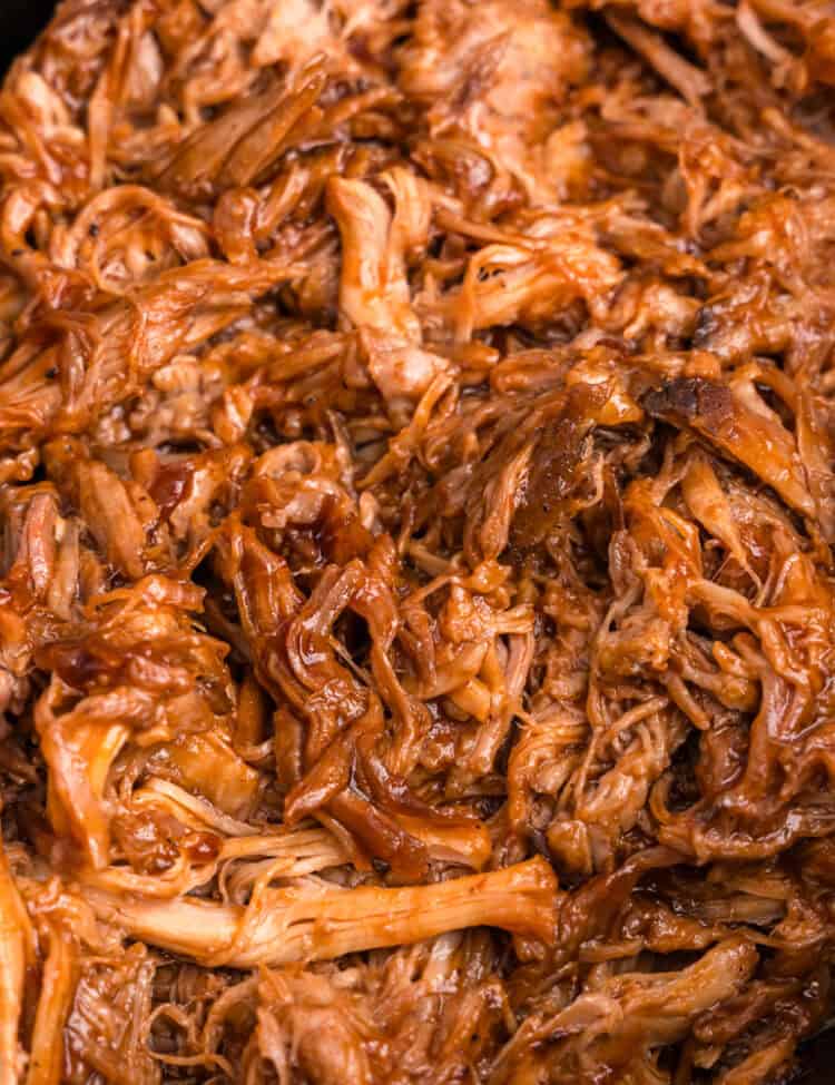 Close up picture of pulled pork cooked in black crock pot