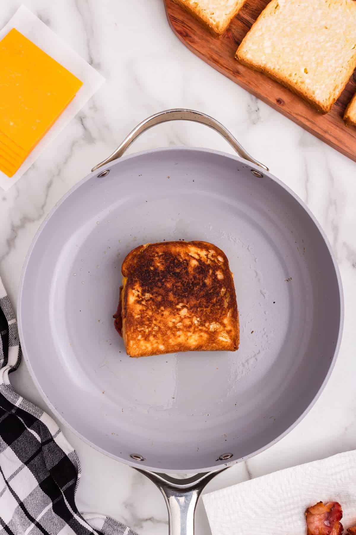 Overhead picture of frying pan with completed Bacon Grilled Cheese on it.