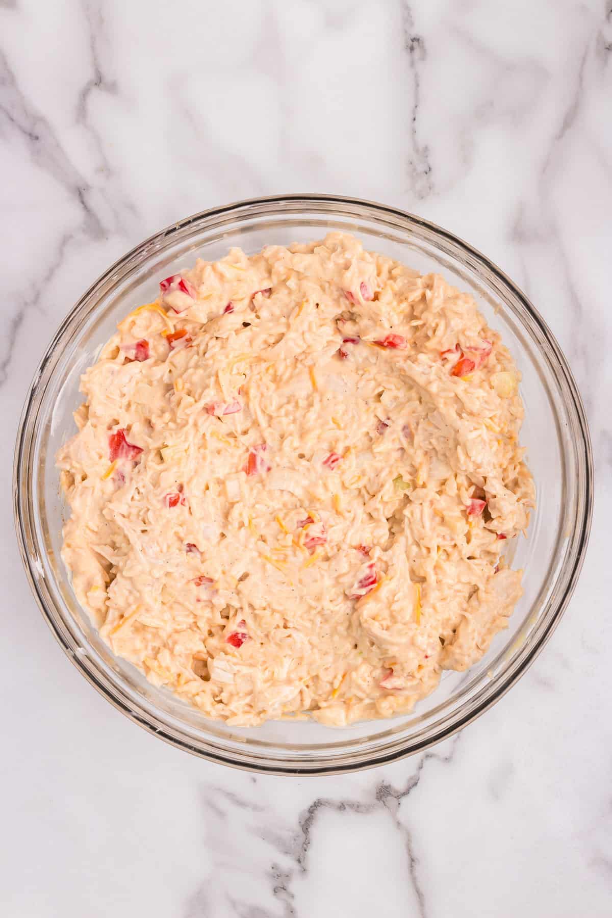 Overhead picture of glass bowl with combine casserole ingredients in it.
