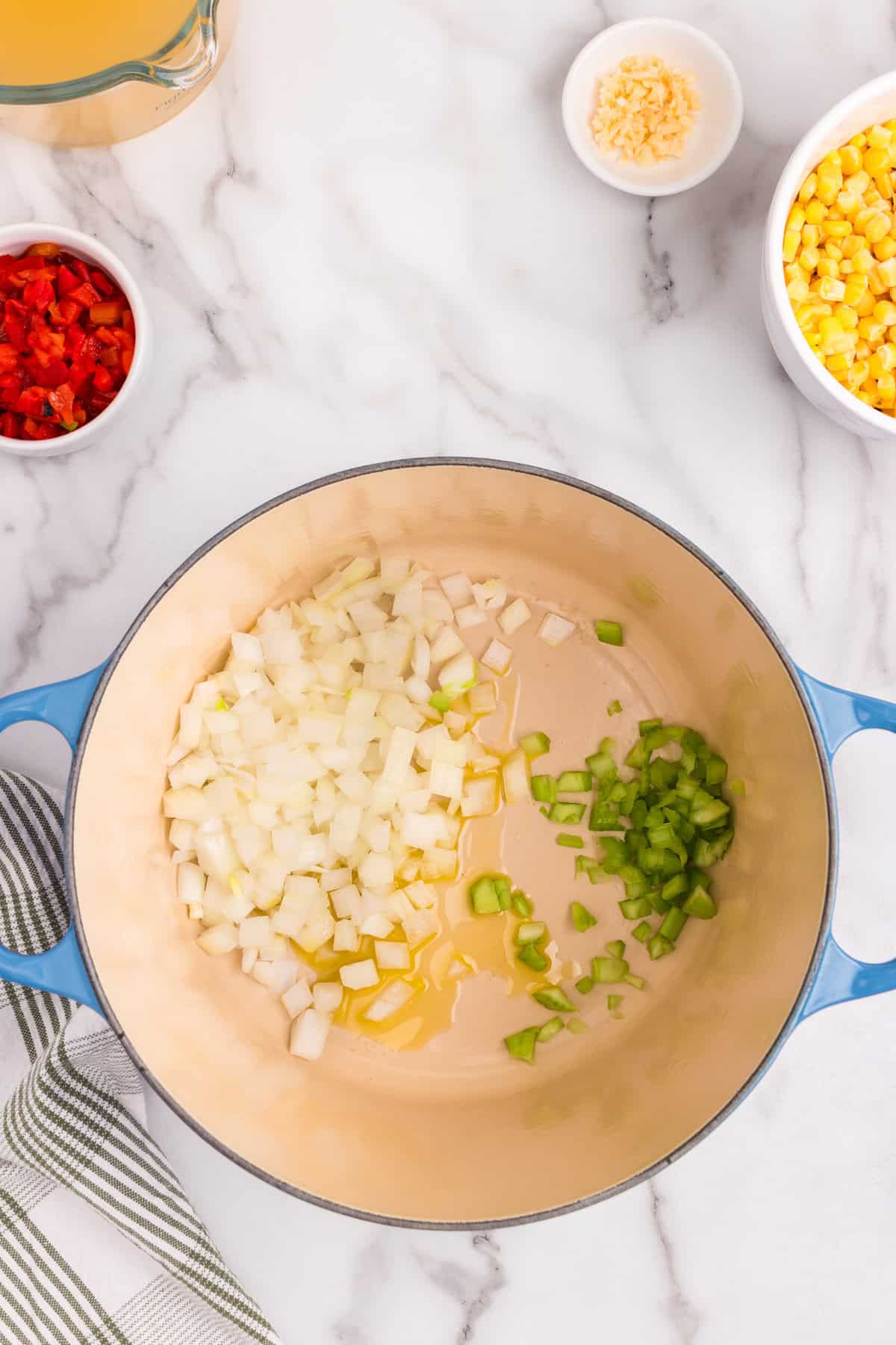 Overhead picture of uncooked chicken and corn chowder ingredients in a pot.