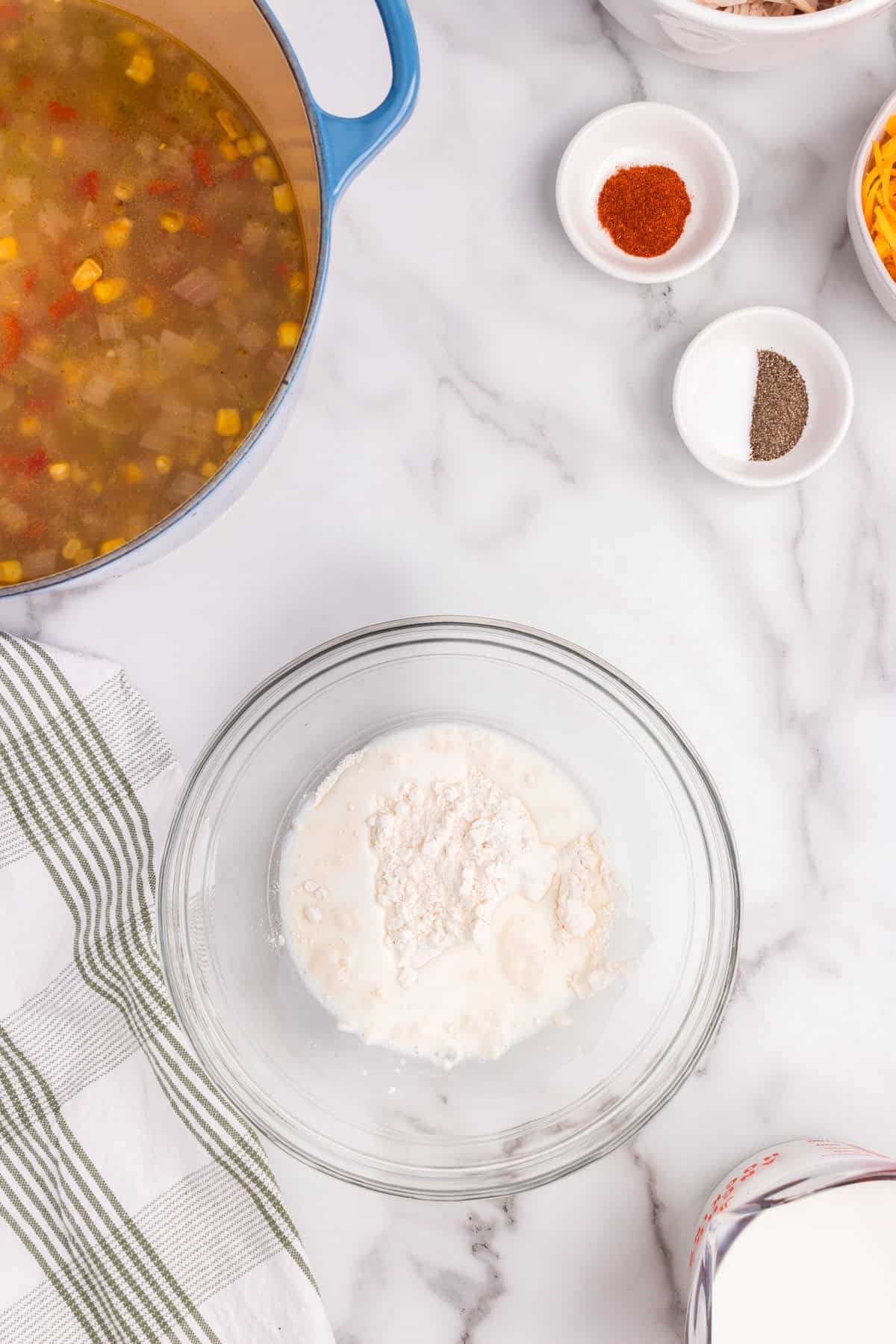 Overhead picture of chicken and corn chowder ingredients with flour and seasonings separated into bowls.