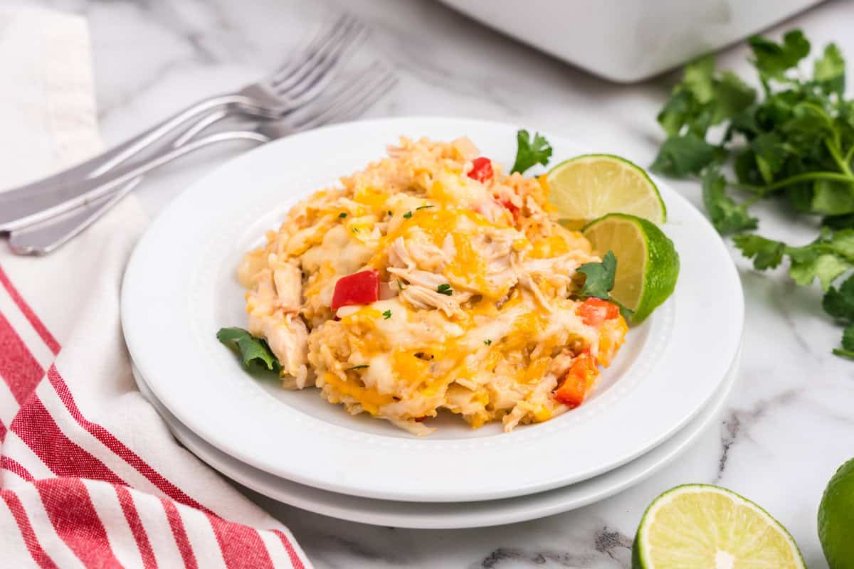 White plate with completed Chicken Fajita Casserole and limes on it.