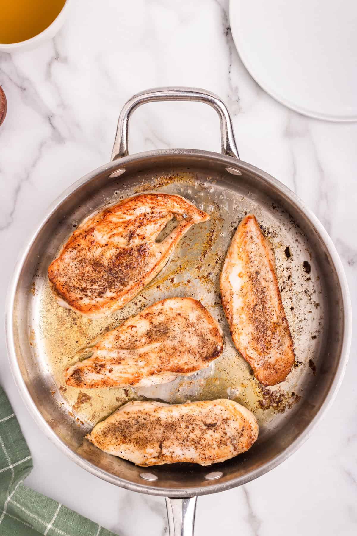 Overhead picture of cooked chicken breast in a meatal pan